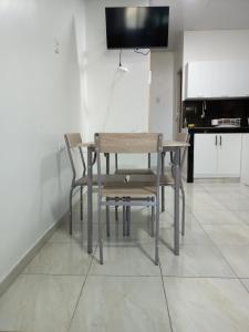 a wooden table and chairs in a room at MiniSuite in Machala