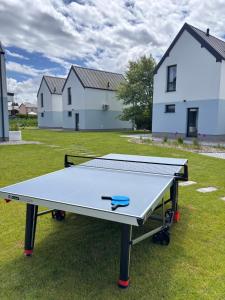 a ping pong table in a yard with houses at Siedlisko na wydmach,domki klimatyzowane,starlink internet,parking in Łeba