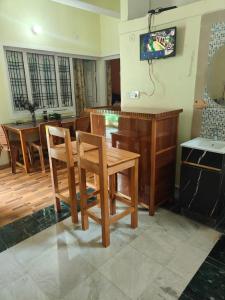 a dining room with a table and chairs and a television at MP Residency Homestay in Munsyari