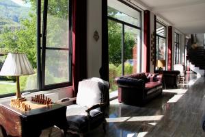 a living room with chairs and a table and windows at Vardzia Resort in Vardzia