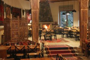 a restaurant with tables and chairs and a fireplace at Vardzia Resort in Vardzia +106 photos