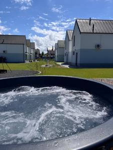a large tub filled with water in front of buildings at Siedlisko na wydmach,domki klimatyzowane,starlink internet,parking in Łeba