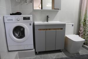 a bathroom with a washing machine and a sink at Khan Dobo in Bokonbayevo