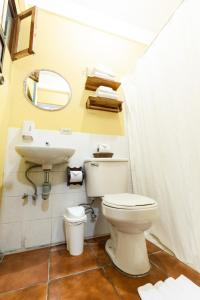 a bathroom with a toilet and a sink at Arbol de Fuego Eco-hotel in San Salvador