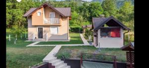 a small house with a yard with a yard at Vila-kuca"Jasmin"pored rijeke i jezera in Konjic