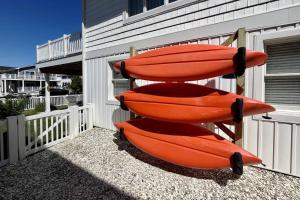 three orange kayaks sitting on a rack next to a building at 47 Oyster Bay Dr, Fenwick Island in Fenwick Island