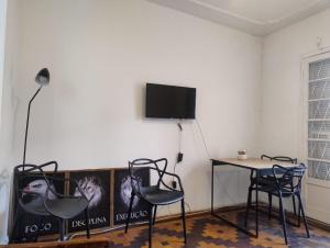 a room with a table and two chairs and a tv at Pousada in Porto Alegre