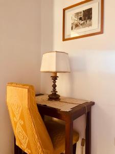a lamp sitting on a table next to a chair at Affittacamere La Mattonata in Città di Castello