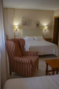 a hotel room with a bed and a chair at Hotel La Brañina in Villablino