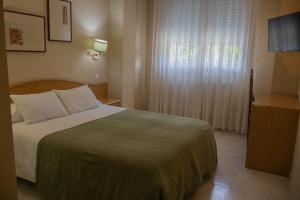 a hotel room with a bed and a window at Hotel La Brañina in Villablino