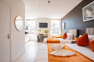 a hotel room with two beds and a mirror at Dublin Central Suites in Dublin