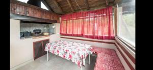 a small room with a table and a red curtain at Vila-kuca"Jasmin"pored rijeke i jezera in Konjic