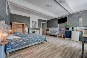 a large bedroom with a bed and a kitchen at lemasrocamour in Roquemaure