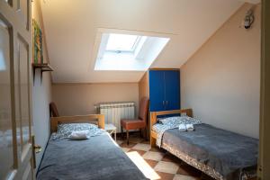 a bedroom with two beds and a skylight at Rooms Asceric in Stari Banovci