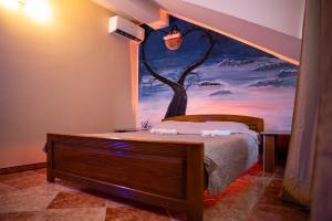 a bedroom with a bed with a painting on the wall at Rooms Asceric in Stari Banovci