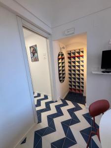 a hallway with black and white tiled floors and a red chair at Bordo piazza in Vasto