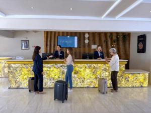 a group of people standing at a counter with luggage at HAMILTON Agadir in Agadir +72 photos