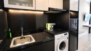 a kitchen with a sink and a washing machine at SleepRest @ NTC in Nagoya