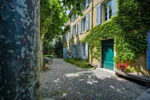 an alley with a green door in a building at lemasrocamour in Roquemaure