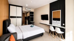 a bedroom with a bed and a desk and chairs at SleepRest @ NTC in Nagoya