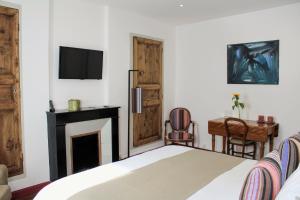 a bedroom with a bed and a fireplace and a tv at L'Hostalet in Argelès-sur-Mer