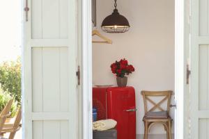 a door open to a room with a red refrigerator at Masseria Borgo Sentinella in Torre dell'Orso