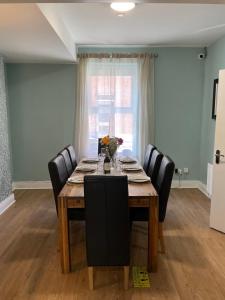 a dining room with a table with chairs and a window at Chamberlain House in Derry Londonderry