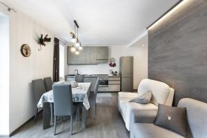 a living room and kitchen with a table and chairs at Angels Home 3-AffittiPontediLegno in Ponte di Legno +14 photos