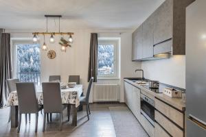 a kitchen and dining room with a table and chairs at Angels Home 3-AffittiPontediLegno in Ponte di Legno
