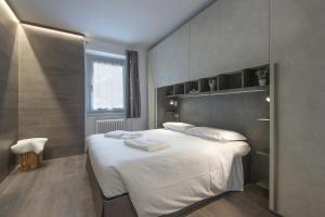 a bedroom with a large bed with white sheets at Angels Home 3-AffittiPontediLegno in Ponte di Legno