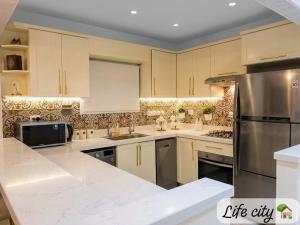 a kitchen with white cabinets and stainless steel appliances at Life city home in 6th Of October