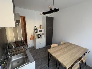 a kitchen with a table and a sink and a table and a kitchen sidx sidx at Le cocon de la Citadelle in Chalon-sur-Saône