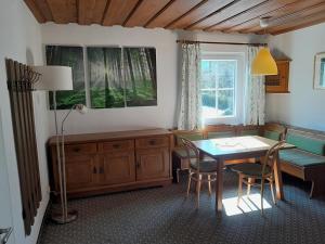 a dining room with a table and chairs and a window at Appartementhaus Huber in Abersee