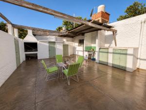 a patio with a table and green chairs on it at La Casa de Pilar - Casa Completa con Cochera y Patio in San Juan