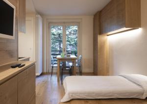 a bedroom with a bed and a table and a window at Bijoux Sozzine - AffittiPontediLegno in Ponte di Legno