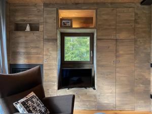 a living room with a fireplace and a window at Chalet Baita Aria - AffittiPontediLegno in Ponte di Legno