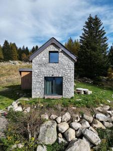 a stone house on top of a hill with rocks at Chalet Baita Aria - AffittiPontediLegno in Ponte di Legno