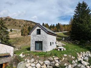 a stone house on the side of a hill at Chalet Baita Aria - AffittiPontediLegno in Ponte di Legno +26 photos