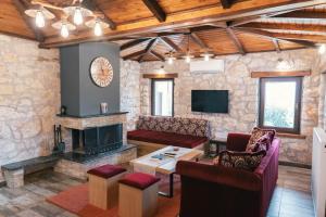 a living room with a fireplace and a tv at Κτήμα Βασίληγιάννη in Kouklésion