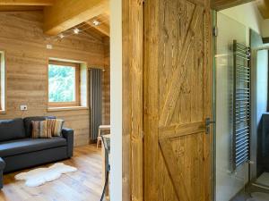 a living room with a wooden door and a couch at Chalet la Mia Baita - AffittiPontediLegno in Pezzo