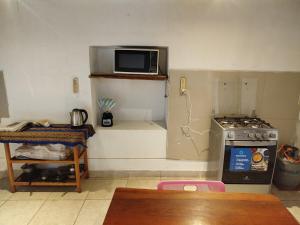 a kitchen with a stove and a microwave on the wall at Los Laureles Sacred valley in Urubamba +17 photos