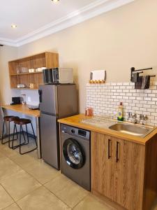a kitchen with a sink and a washing machine at River Suite at On-the-Up in Potchefstroom