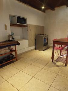 a kitchen with a table and a microwave on the wall at Los Laureles Sacred valley in Urubamba