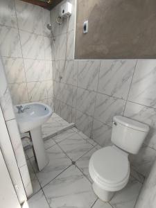 a white bathroom with a toilet and a sink at Los Laureles Sacred valley in Urubamba