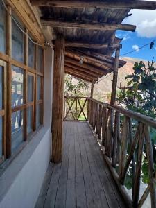 a wooden balcony of a house with a wooden door at Los Laureles Sacred valley in Urubamba