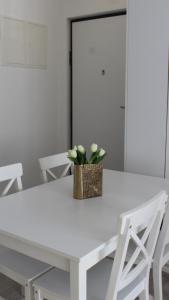 a white table with a basket of flowers on it at Apartman Lejla in Bjelašnica