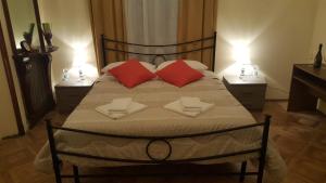um quarto com uma cama grande e almofadas vermelhas em Garden Suite em Génova