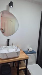 a bathroom with a sink and a mirror on a table at Ckoinatur Hostel in San Pedro de Atacama