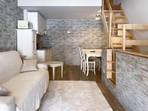 a living room with a couch and a table and a kitchen at Fiocco di Neve - AffittiPontediLegno in Passo del Tonale