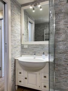 a bathroom with a sink and a mirror at Fiocco di Neve - AffittiPontediLegno in Passo del Tonale +25 photos